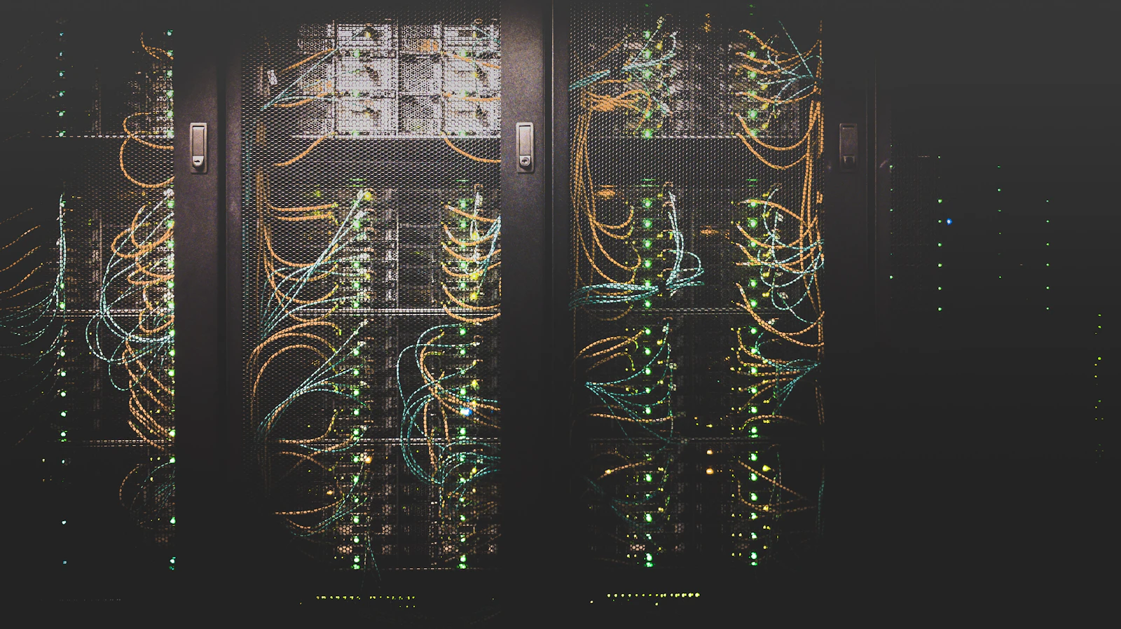 Infrastructură de rețea cu numeroase cabluri ordonate într-un rack de servere