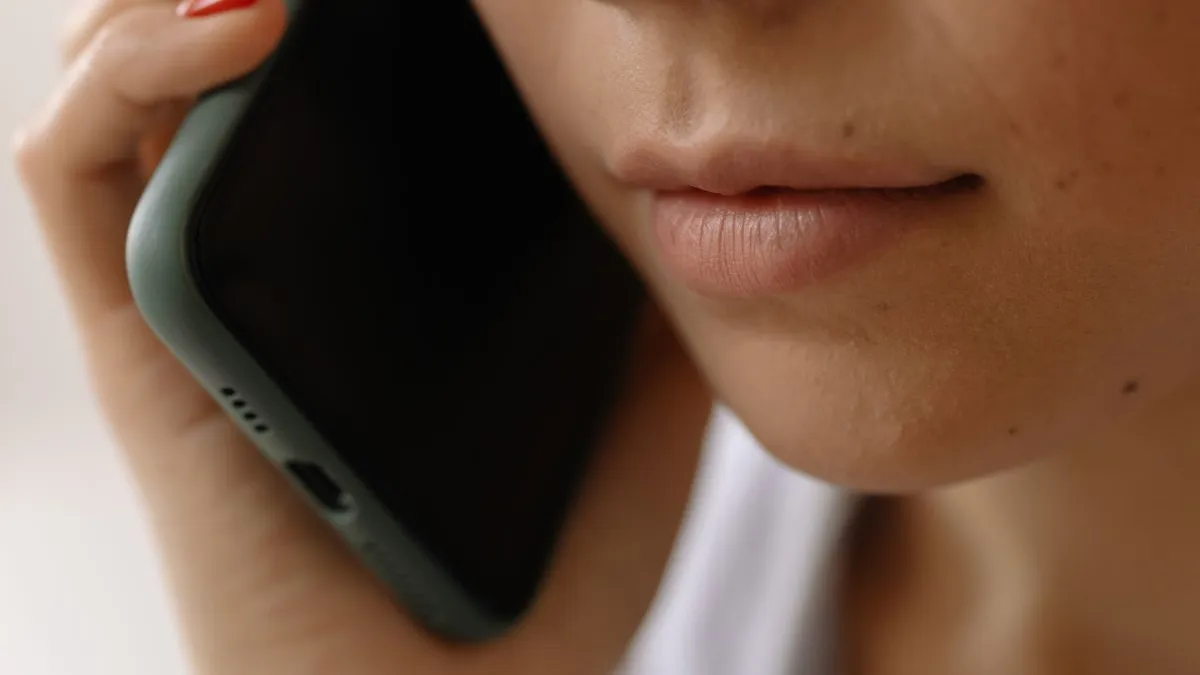 Prim-plan cu o persoană care vorbește la telefon, primind un apel necunoscut