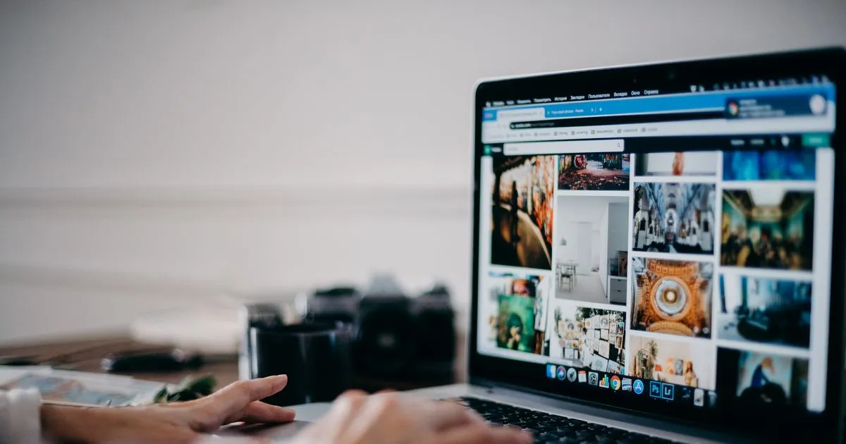 Mâini pe un laptop care afișează un site în browser