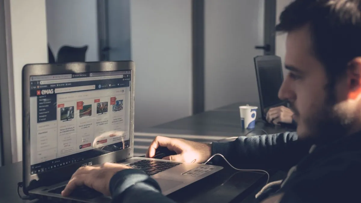 Proprietar de afacere lucrând la laptop într-o încăpere slab luminată